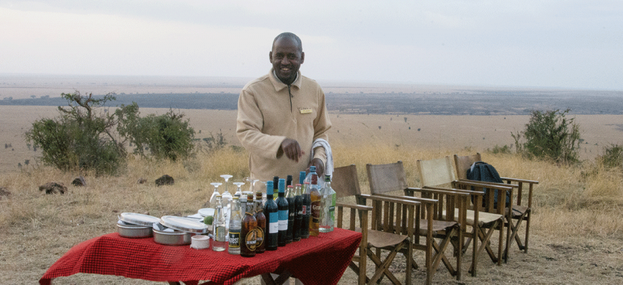 Give your classic safari game drive a perfect send off with sundowner drinks in a breathtakingly beautiful location on the famous plains of Serengeti which commands magnificent views over the vast Serengeti national park. Sip on an ice cold gin and tonic, a sparkling glass of champagne or your favourite cocktail as the dusk gently deepens around you and the sun sinks slowly over the Serengeti plains and the landscape. The evening sounds of the African wild will slowly quieten as the wildlife species seek shelter for the night and the predators begin to prepare for their nocturnal hunts. Contemplating the silence of the vast sweeping plains, your eye is drawn to a herd of wildebeest and buffalo slowly making their way to the open plains for the night .Carving another path, the wildebeest trudge up the escarpment slope to the same liquid haven. Here the little ones stick closely to their mothers. Creating a magnificent wild backdrop, zebras and giraffe amble past each other and quirky warthogs go down on bended knee to forage in scrubby brush. Cast your gaze further back and you may see jackal sneaking ever closer. This is a glorious time to relish the daily ritual of life in the wild as it unfolds naturally before you. Types of Sundowner in Serengeti national park Lodge sun downers This are the best sun downers in the Serengeti where you will head out for the game drive and catch up with the hotel staff at an agreed location, you will find when they have perfectly lined ice cold drinks with lemon slices and ice blocks and the chicken wings and fingers will be out in the dish and you will immediately quench your thirsty, usually the location will have dramatic views of landscapes or wildlife and this is perfect for family and group safaris Guide arranged vehicle sun downers This one is usually arranged by the guide, the guides will pack drinks and snacks in cooler boxes before the start of the game drive and you will head out for the drive and as the sun starts setting your safari guide will lay a perfect masai cloth on the car bonnet and align the drinks perfectly and you will enjoy ice cold drinks this is perfect for private safaris Perfect timing for sunset and sundowners in Serengeti national park Depending on the time of the year you need to be at the strategic point for the sun downer before 6:30 pm as the sunset is usually from 6:45-7:15 and later you will drive to the lodge for dinner and overnight